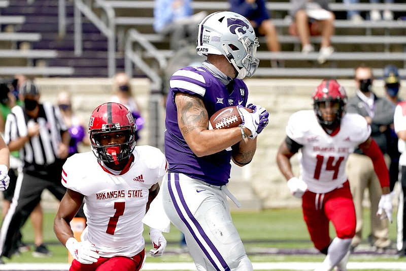 Kansas State tight end Briley Moore (0) catches a pass in the end zone to score a touchdown during the first half of an NCAA college football game against Arkansas State in Manhattan, Kan., on Saturday, Sept. 12, 2020. Pursuing Moore are Red Wolves wide receiver Roshauud Paul (1) and defensive back Antonio Fletcher (14).