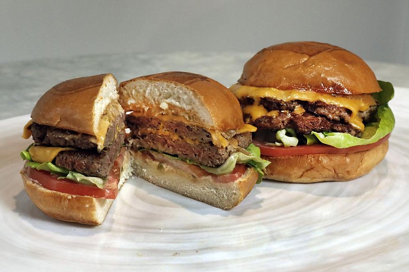 An Original Impossible Burger (left) and a Cali Burger, from Umami Burger, sit side by side in this 2019 photo. American plant-based meat company Impossible Foods Inc. is awaiting regulatory approval to enter the China market, while rivals are pushed forward with plans to set up production in China.
(AP)