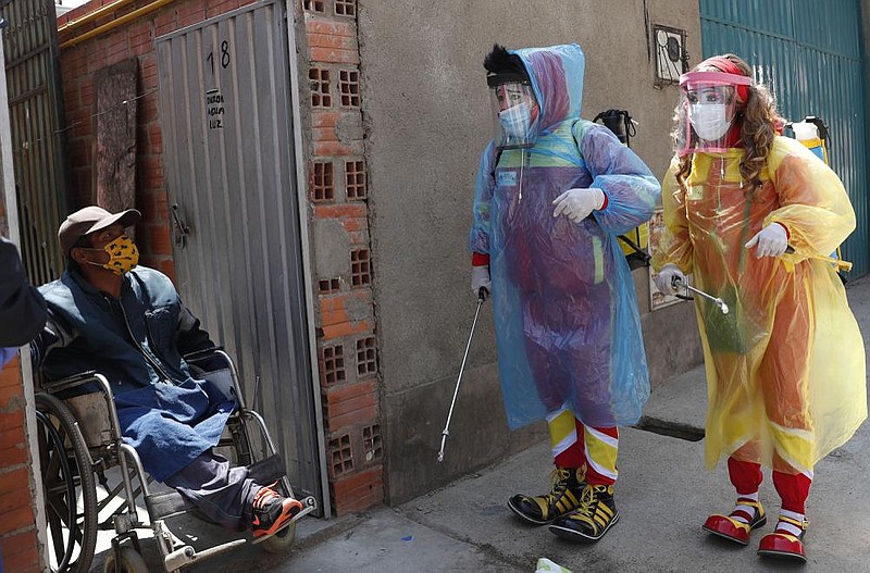 Clowns Perlita and Tapetito arrive to disinfect the home of Enrique Zeballos free of charge Friday in El Alto, Bolivia. The lack of traditional employment for the clowns because of the pandemic has led them toward other avenues of making money. But for people with limited income, they provide their disinfection services for free.
(AP/Juan Karita)