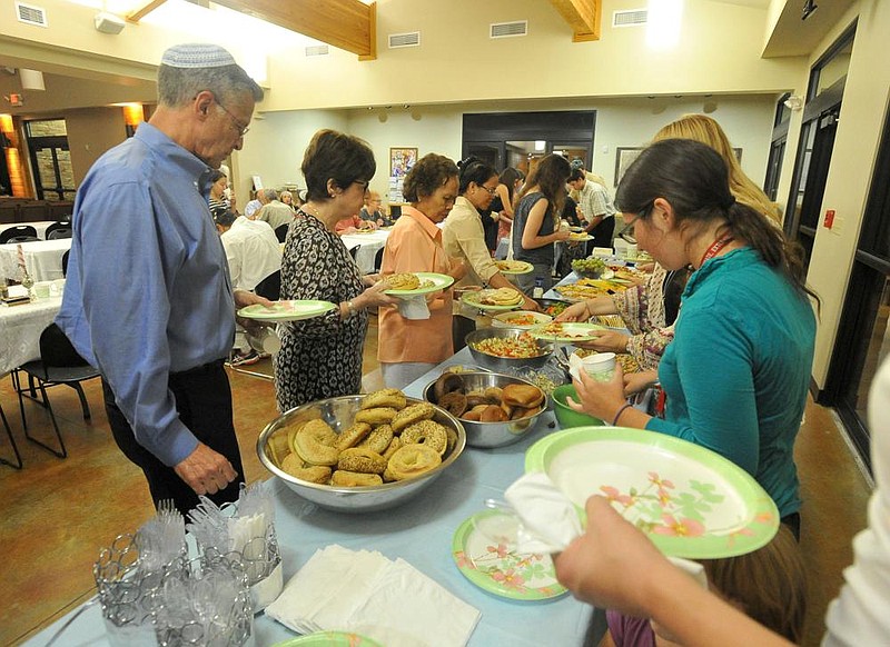 Temple members load up on food as they break their fast following the end of Yom Kippur in this 2015 file photo at Temple Shalom of Northwest Arkansas in Fayetteville. The temple has adapted its High Holy Day services this year due to the coronavirus pandemic.
(NWA Democrat-Gazette/Michael Woods)