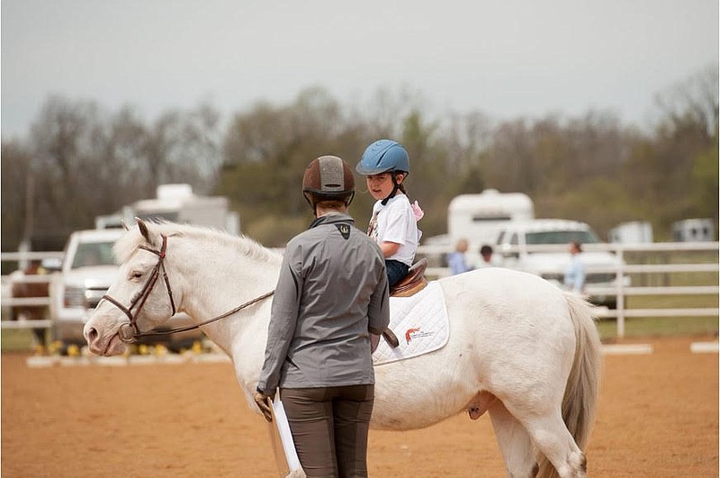 Megan Smits, Horses for Healing executive director, helps Alexis Sifuentes ride Milo at the nonprofit organization’s farm in Bentonville. (Submitted photo)