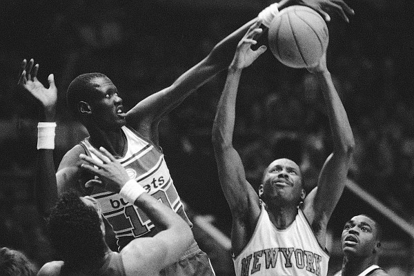 New York Knickerbockers Darrell Walker (4) gets the ball away from Washington Bullets Manute Bol (10) during game at New York’s Madison Square Garden on Thursday, Jan. 3, 1986. Knicks Gerald Wilkins (21), right, and Ernie Grunfeld (18), left, and Bullets Cliff Robinson (4), center, watch the action. The Bullets beat the Knicks 115-109. (AP Photo/Richard Drew)