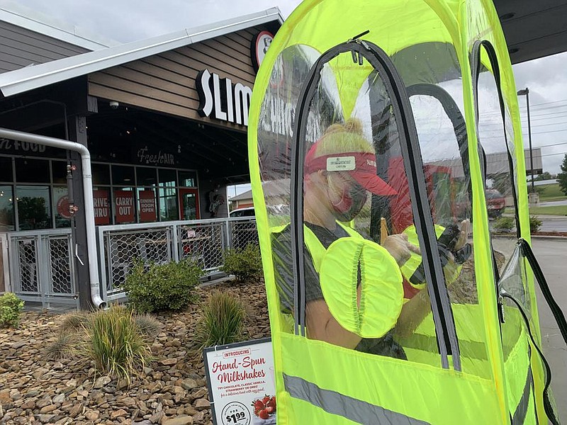 Caitlin Taylor takes an order at Slim Chickens on Thursday at 5240 W. Sunset Ave. in Springdale. The locally based restaurant chain continues to expand nationally and has capitalized on its drive-thru and curbside pickup during the pandemic. (NWA Democrat-Gazette/Andy Shupe) 
