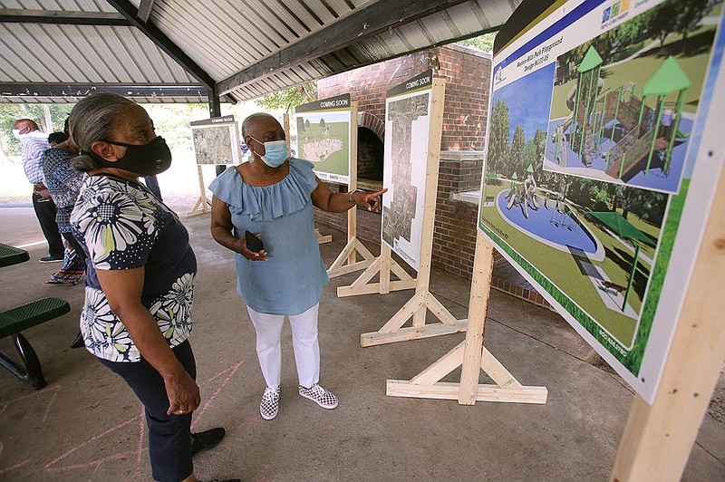 Rosalyn Scruggs (left) and Eleanor Stephenson with the South End Neighborhood Coalition Group look at maps of projected parks projects before Thursday’s groundbreaking ceremony for one of them at Crump Park in Little Rock. The total $1.3 million project in- cludes work at Crump, Dunbar, Hindman and Western Hills parks. Also, the city Parks and Recreation Department now has a green light to seek $1.1 million in grants for improvements at MacArthur and Wakefield Parks, and the Tri Creek Parkway. 