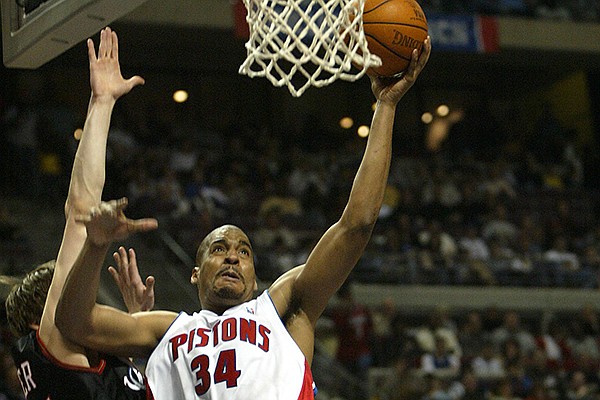 Detroit Pistons' Corliss Williamson, center, drives past Philadelphia 76ers defenders Kyle Korver, left, and Willie Green, background right, during the third quarter Sunday, March 14, 2004, in Auburn Hills, Mich. Williamson led the Pistons with 16 points in their 85-69 win. (AP Photo/Paul Sancya)