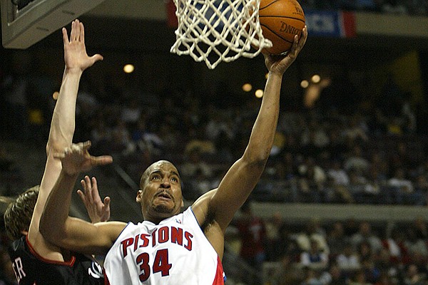Detroit Pistons' Corliss Williamson, center, drives past Philadelphia 76ers defenders Kyle Korver, left, and Willie Green, background right, during the third quarter Sunday, March 14, 2004, in Auburn Hills, Mich. Williamson led the Pistons with 16 points in their 85-69 win. (AP Photo/Paul Sancya)

