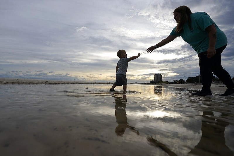 Nikita Pero of Gulfport, Miss., walks with her son Vinny Pero, 2, on the beach along the Gulf of Mexico in Biloxi, Miss., Monday, Sept. 14, 2020. Hurricane Sally is expected to make landfall along the Gulf Coast sometime through the night and morning. (AP Photo/Gerald Herbert)

