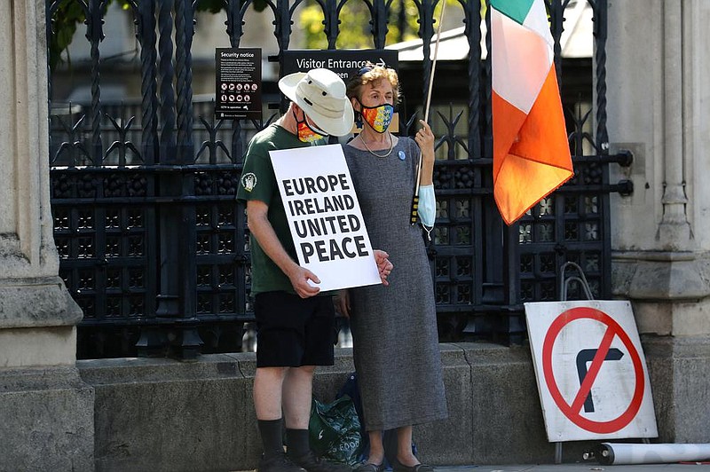 Pro EU protesters stand near Parliament in London, Monday, Sept. 14, 2020. Boris Johnson is facing the possibility of a Tory rebellion and major damage to his chances of a trade deal with the EU unless he removes controversial parts of the internal Bill which is in the House of Commons for its second reading Monday. (AP Photo/Frank Augstein)