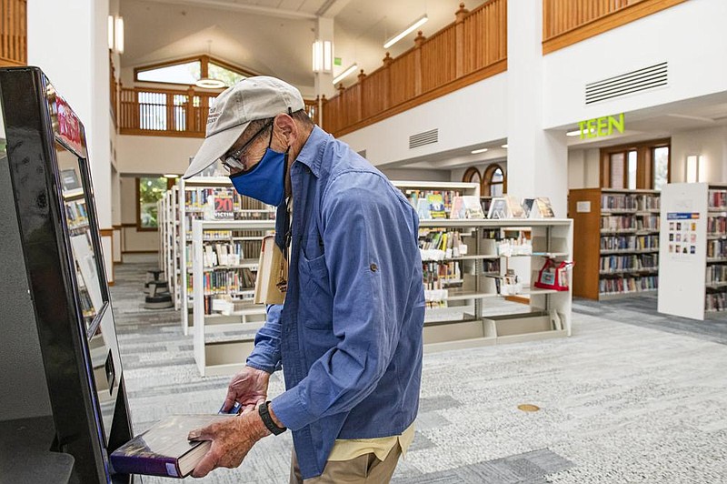 Lubert Stryer checks out two books Monday from the just re- opened Pitkin County Library in Aspen, Colo., where he jokingly told librarians that it was nice to find almost all of the books checked in. 
(AP/The Aspen Times/Kelsey Brunner) 