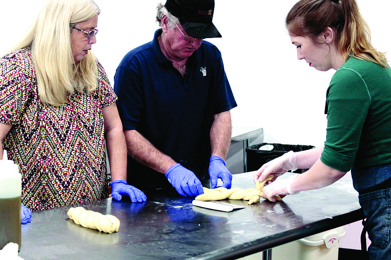 Michael Roberts, center, braids challah dough with the help of Lillian Ellen, director of South Arkansas Community College’s Culinary Arts program. Denise Roberts, left, looks on. Ellen hosted a bread baking workshop in January as part of a series of community classes SouthArk offered earlier this year; she will host a Pumpkin Carving and Cooking class on October 10 and a holiday cooking class on October 29. (News-Times/Caitlan Butler)