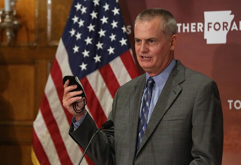 Lance Taylor, executive director of the Arkansas Activities Association, holds up a mask and says "This is the key making it through the fall with high school sports" during the daily covid-19 press briefing on Friday, Aug. 14, 2020, at the state Capitol in Little Rock. 
See more photos at www.arkansasonline.com/815briefing/
(Arkansas Democrat-Gazette/Thomas Metthe)