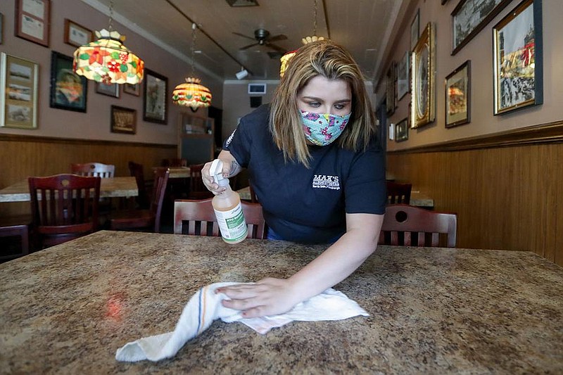 Sara Kennely wipes down a table at Max’s Allegheny Tavern in Pennsylvania in June. Researchers are interested in the effectiveness of routine cleaning against the spread of the coronavirus. (AP/Keith Srakocic) 