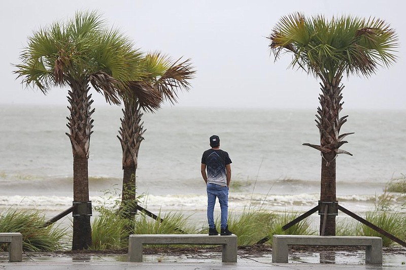 A man watches as rough surf overtakes Buffett Beach in Pascagoula, Miss., on Tuesday afternoon. The slow-moving Hurricane Sally is driving a tidal surge and rains toward communities along the Gulf Coast. More photos at arkansasonline.com/916hurricane/. (AP/The Sun Herald/Alyssa Newton) 