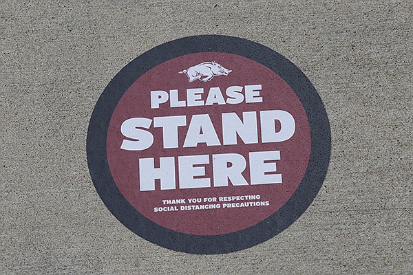 A placard is shown Thursday, Sept. 17, 2020. on the ground at Donald W. Reynolds Razorback Stadium in Fayetteville. The University of Arkansas has added signage across its football stadium to help fans maintain distance this season. 