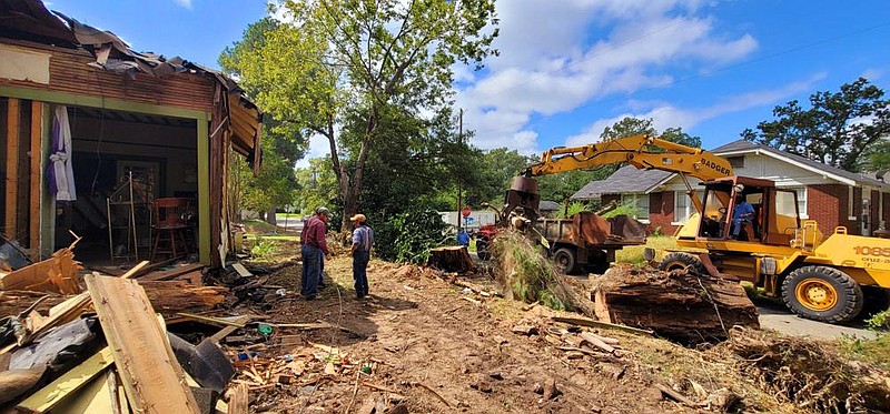 Community volunteers demolish a home on the 700 block of West 23rd Avenue that was damaged by a fallen tree during the Easter storm in Pine Bluff. 
(Pine Bluff Commercial/Eplunus Colvin)