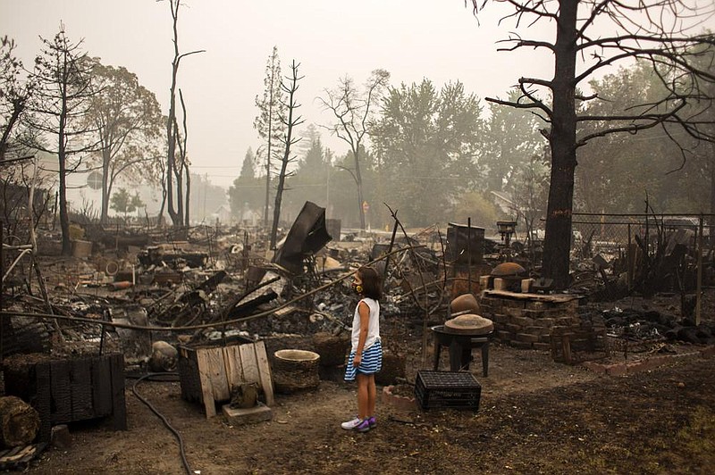 Izel Ramos-Gonzalez, 7, looks over her grandmother’s backyard in Phoenix, Ore., on Sept. 12. Area officials estimated that nearly 1,800 houses and businesses were destroyed in the Almeda Fire last week, which burned through parts of Phoenix and nearby Talent.
(The New York Times/Alisha Jucevic)