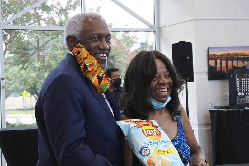 Fort Smith Mayor George McGill (left) stands with Charolette Tidwell, founder and executive director of Antioch for Youth and Family, on Tuesday, Sept. 15, 2020, during a Fort Smith reception in Tidwell's honor. Tidwell is one of 30 people chosen for the Smile with Lay’s campaign. The two are holding a bag of Lay’s classic lightly salted chips with Tidwell's smile on the bag.