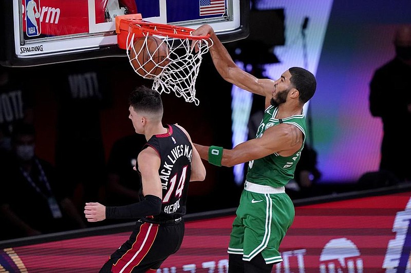 Boston Celtics forward Jayson Tatum (right) dunks the ball as Tyler Herro of the Miami Heat defends during the first half of Game 3 of the NBA Eastern Conference finals Saturday in Lake Buena Vista, Fla. Tatum had 25 points, 14 rebounds and 8 assists as the Celtics won 117-106 to narrow their series deficit to 2-1. (AP/Mark J. Terrill) 