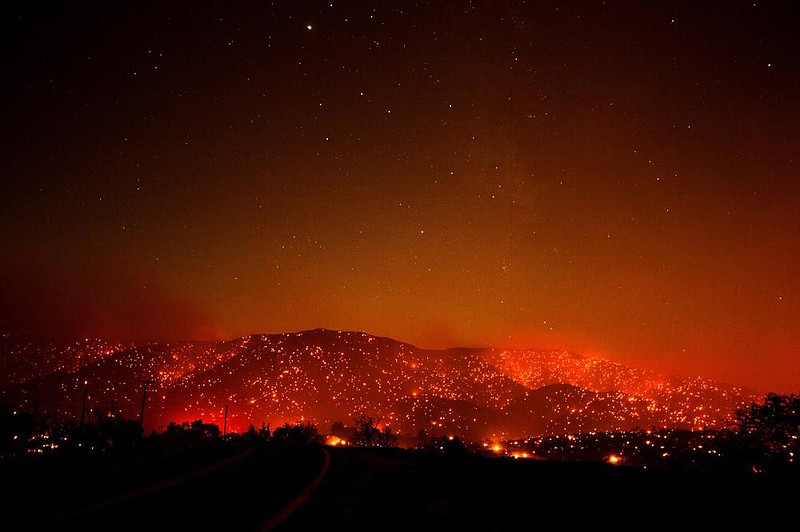 A wall of flames and embers looms in Juniper Hills, Calif. More photos at arkansasonline.com/920wildfires/. (AP/Ringo H.W. Chiu) 