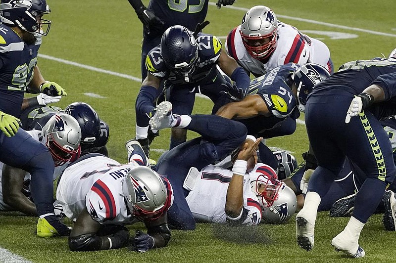 New England Patriots quarterback Cam Newton lands on his back after he was stopped near the goal line as the clock expires in the fourth quarter Sunday against the Seattle Seahawks, who won 35-30. (AP/Elaine Thompson)