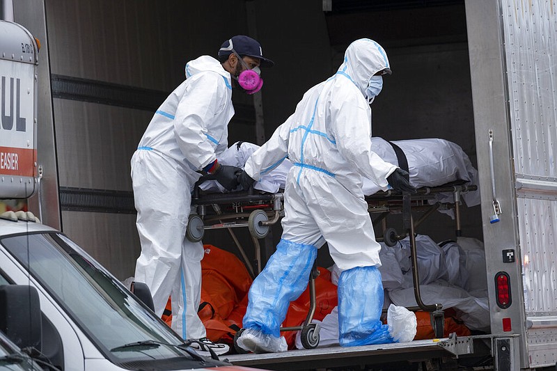 FILE - In this April 29, 2020, file photo, workers move bodies to a refrigerated truck from the Andrew T. Cleckley Funeral Home in the Brooklyn borough of New York. During the deadliest days of the coronavirus outbreak in New York City, the bodies piled up at the funeral home — and the stench that came with it — at an alarming rate. Cleckley says what happened next made him the scapegoat for an unforeseen crisis — hundreds of COVID-19 deaths a day in New York that overwhelmed funeral homes across the city. Authorities swept in and suspended his license in an episode that made headlines in a city already reeling from other horrors of the pandemic. (AP Photo/Craig Ruttle)

