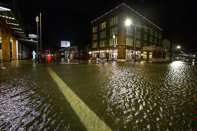 Water rises from the storm surge of Tropical Storm Beta in The Strand as the storm moves toward landfall, late Monday, Sept. 21, 2020, in Galveston, Texas.