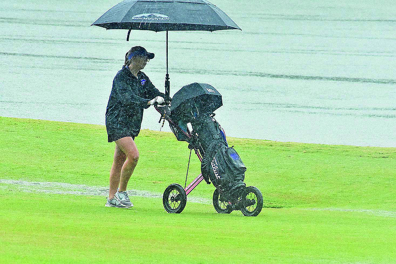 El Dorado's Lani Hammock soldiers on through the rain Tuesday during the 5A South Conference Golf Tournament at Mystic Creek. El Dorado's boys and girls both swept the championships.