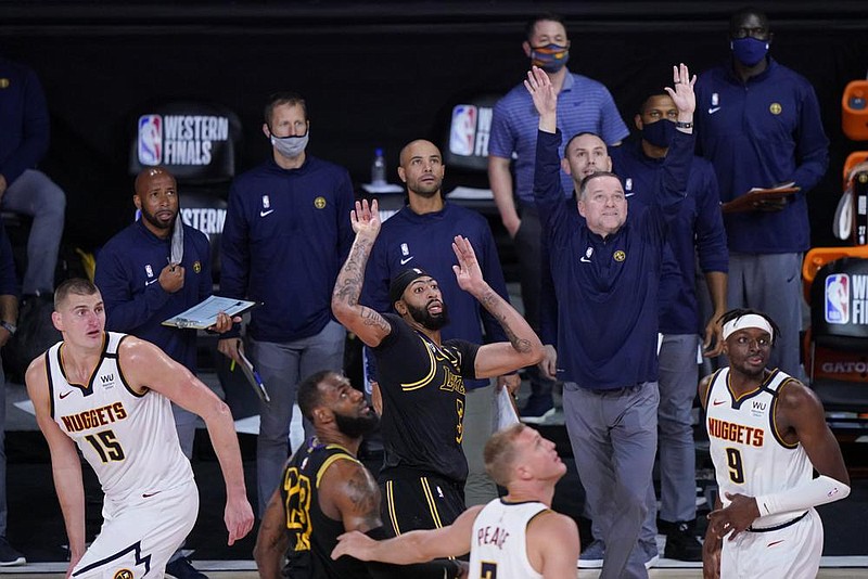 Los Angeles Lakers’ Anthony Davis (center) watches his buzz- er-beater three-pointer to give the Lakers a 105-103 victory over the Denver Nuggets on Sunday in Game 2 of the Western Con- ference final. It was the first time Davis has made a buzzer-beater in the postseason. 
(AP/Mark J. Terrill) 
