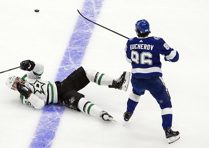 Blake Comeau (left) of the Dallas Stars is checked by Nikita Kucherov of the Tampa Bay Lightning during the the second pe- riod of Game 2 of the Stanley Cup Final on Monday in Edmonton, Alberta. The Lightning won 3-2 to even the series at 1-1. (AP/The Canadian Press/Jason Franson) 