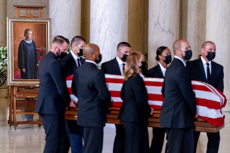 The flag-draped casket of Justice Ruth Bader Ginsburg, carried by Supreme Court police officers, arrives in the Great Hall at the Supreme Court in Washington, Wednesday, Sept. 23, 2020. Ginsburg, 87, died of cancer on Sept. 18.