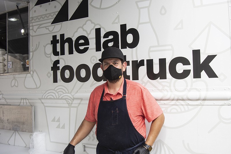 Chef Gilbert Alaquinez poses in front of the Lab Food Truck at a July event at the Historic Arkansas Museum.
(Arkansas Democrat-Gazette/Cary Jenkins)