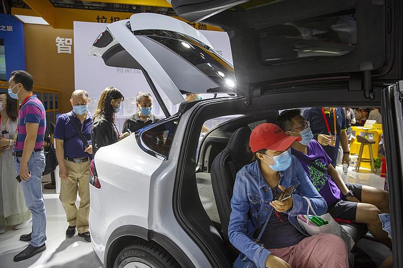 Visitors look at a Tesla Model X SUV displayed Saturday at the China International Fair for Trade in Services in Beijing. (AP/Mark Schiefelbein) 