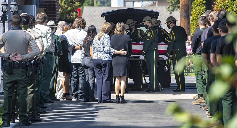 Family and members of the Big Bear Hotshots watch Tuesday as U.S. Forest Service pallbearers move the casket of fallen re ghter Charles Morton in Orange, Calif., after a funeral procession from San Bernardino. Video at arkansasonline.com/923 re/ and arkansasonline.com/923ca/. (AP/The Orange County Register/Mark Rightmire) 