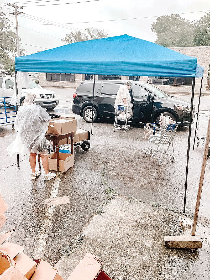 StoreHouse Pantry drive-thru volunteers serve a client during a rainy day. The Conway Ministry Center is hosting a Virtual Feed the Need campaign throughout October. The Virtual Feed the Need event will depend mostly on online monetary donations.