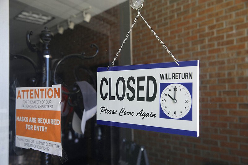 FILE - In this July 18, 2020 file photo a closed sign hangs in the window of a barber shop in Burbank, Calif. California's unemployment rate has fallen to 11.4% in August.