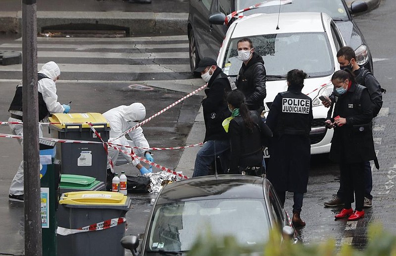 Police officers gather at the site of a knife attack Friday near the former offices of satirical newspaper Charlie Hebdo in Paris.
(AP/Thibault Camus)