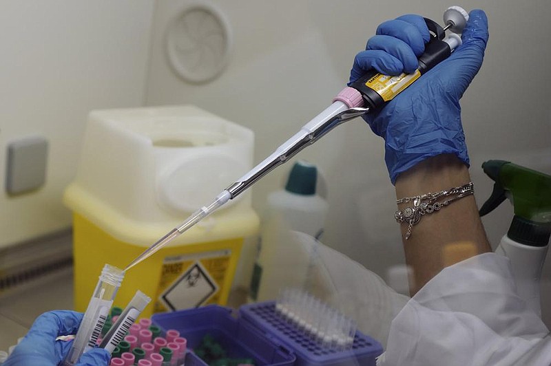 A lab technician prepares nasal swab samples to test for the coronavirus Friday at Hospital of Argenteuil north of Paris. More photos at arkansasonline.com/926virus/.
(AP/Francois Mori)