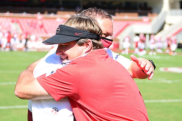 Georgia coach Kirby Smart (front) and Arkansas coach Sam Pittman embrace prior to a game Saturday, Sept. 26, 2020, in Fayetteville. Pittman, who spent four seasons as an assistant coach on Smart's staff, was making his debut as coach at Arkansas. 