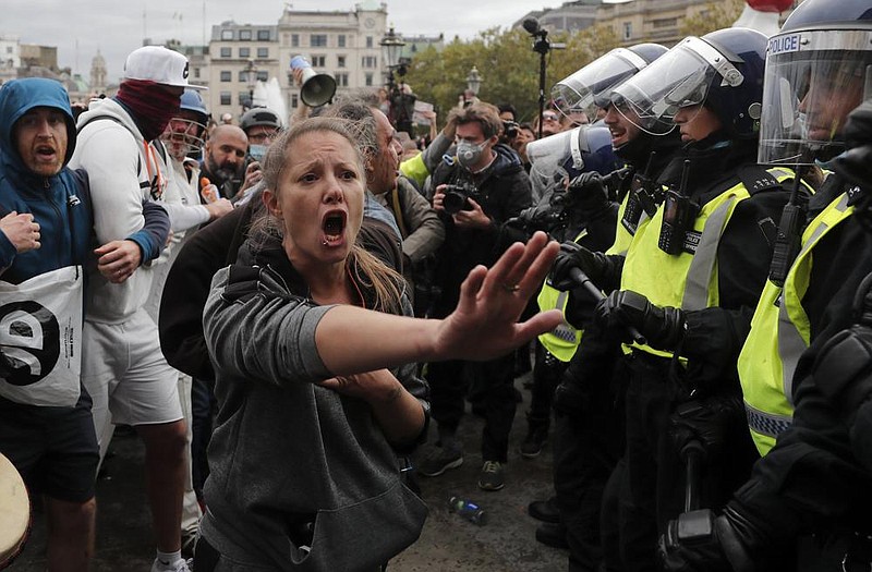 Riot police and protesters square off Saturday during a ‘We Do Not Consent’ rally in Trafalgar Square to protest coronavirus restrictions in London. (AP/Frank Augstein) 