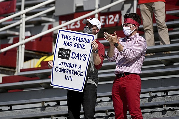 Arkansas fans hold up a sign displaying how many days the Razorbacks have gone since an SEC home victory during a game against Georgia on Saturday, Sept. 26, 2020, in Fayetteville. Arkansas' last SEC victory at home came in November 2016 against Florida. (AP Photo/Michael Woods)
