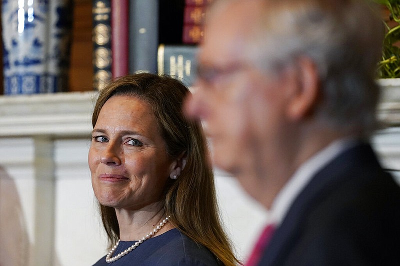 Supreme Court nominee Judge Amy Coney Barrett looks over to Senate Majority Leader Mitch McConnell of Kentucky as they meet with on Capitol Hill in Washington on Tuesday, Sept. 29, 2020.