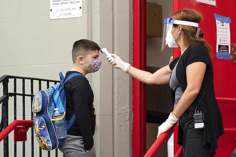 A student has his temperature taken before entering PS 179 elementary school in the Kensington neighborhood, Tuesday, Sept. 29, 2020, in the Brooklyn borough of New York.