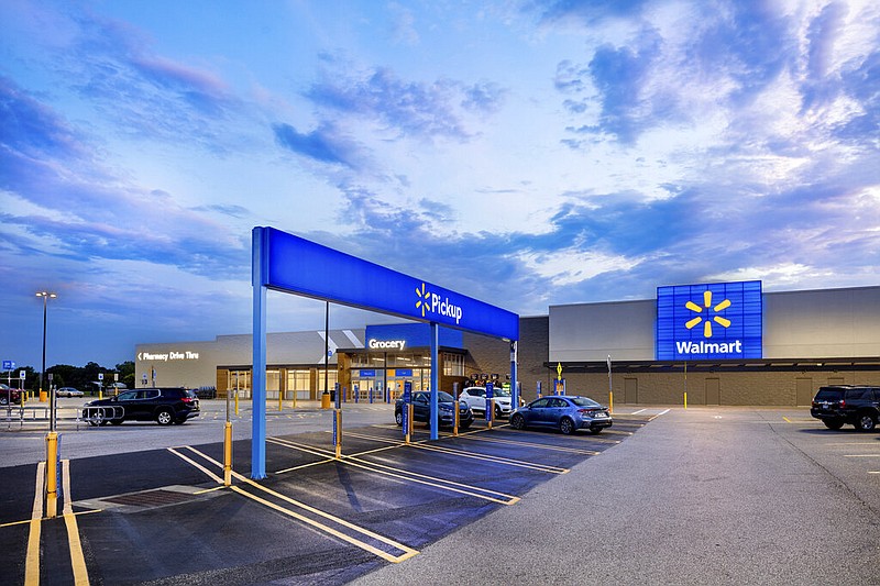 This July 2020 photo provided by Walmart shows the bright signage and Walmart logos from the parking lot outside the Walmart Supercenter in Springdale, Ark. Walmart is getting inspiration from the airport terminal as it revamps the layout and signage of its stores to speed up shopping and better cater to smartphone-armed customers. (Mark Steele + FITCH/Courtesy of Walmart via AP)