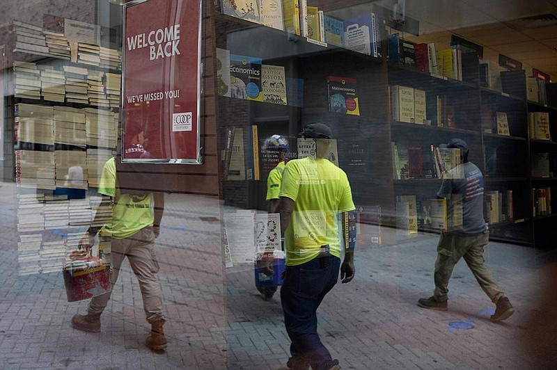 Walkers are reflected in the window of a bookstore Monday in the Harvard Square neighborhood of Cambridge, Mass. U.S. consumer confidence rebounded more quickly in September than most economists had expected. (AP/Steven Senne) 