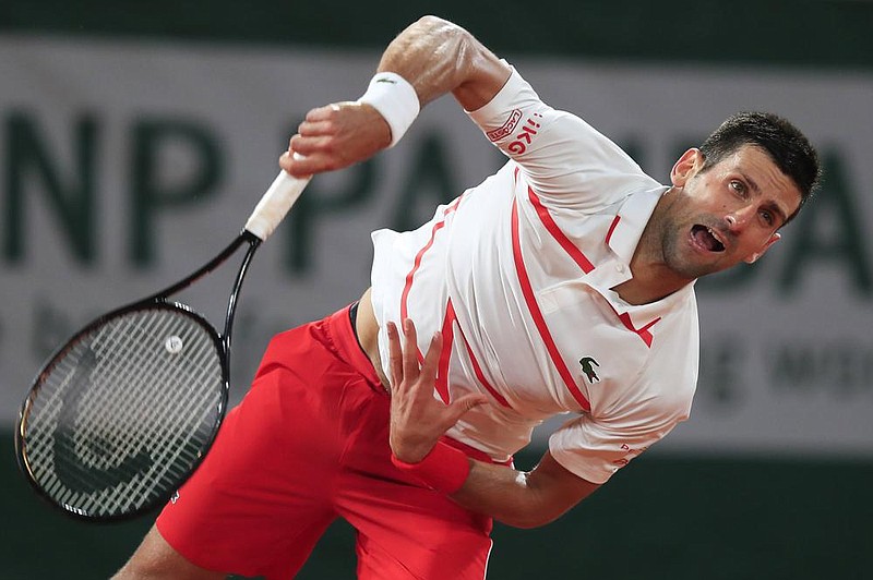 Serbia’s Novak Djokovic serves the ball against Sweden’s Mikael Ymer on Tues- day in the first round of the French Open in Paris. Playing his first Grand Slam match since being disqualified at the U.S. Open, Djokovic won 6-0, 6-3, 6-2. (AP/Michel Euler) 