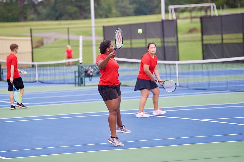 Magnolia senior Sierra Putney returns a hit while playing doubles with classmate Angie Saldana during tennis action on Monday. 