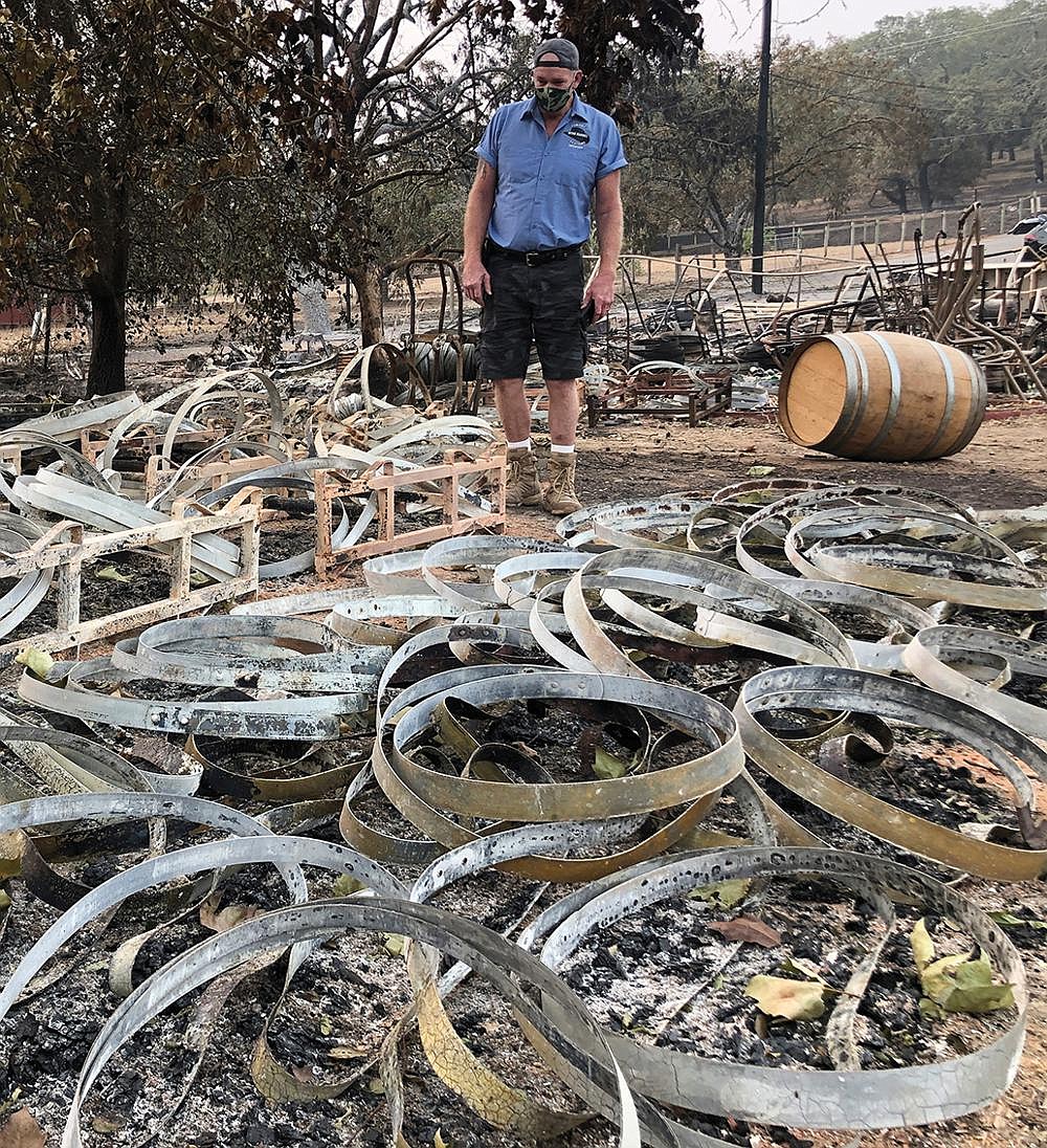 Kevin Conant stands Wednesday amid hundreds of metal rings left from wine barrels that were destroyed when a wildfire swept over his business, Conants Wine Barrel Creations, in Santa Rosa, Calif. Conant and his family escaped with little more than the clothes on their backs. Flames devoured swaths of brush and trees in Northern California on Wednesday as the weather remained hot and dry. More photos at arkansasonline.com/101fires/. Video at arkansasonline.com/101napa/.
(AP/Haven Daley)
