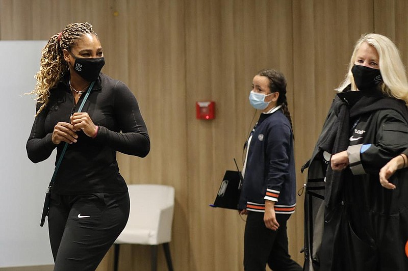 Serena Williams (left) leaves after a news conference in which she announced her withdrawal from the French Open prior to her second-round match because of an Achilles injury.
(AP/Christophe Ena)