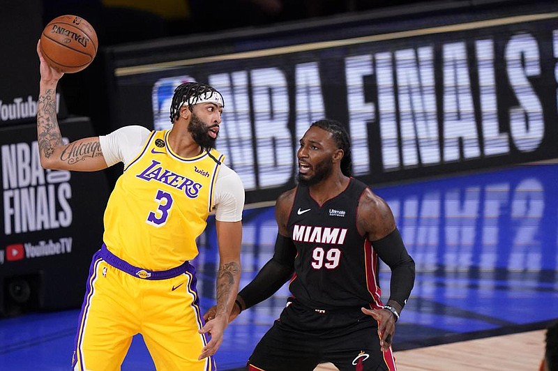 Anthony Davis (left) looks to throw a pass Wednesday against Jae Crowder during the first half of the Los Angeles Lakers’ 116-98 victory over the Miami Heat in Game 1 of the NBA Finals in Lake Buena Vista, Fla.
(AP/Mark J. Terrill)