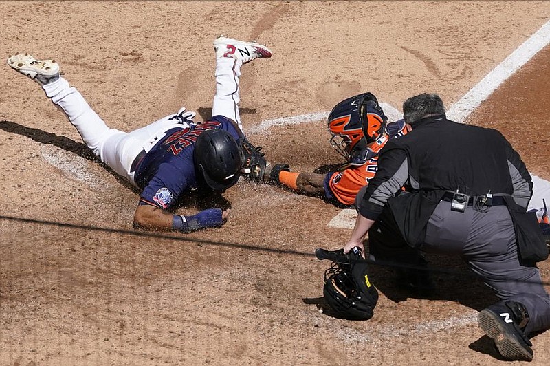 Home plate umpire Manny Gonzalez watches as Minnesota’s Luis Arraez (left) is tagged out by Houston catcher Martin Maldonado as he attempted to score on a Marwin Gonzalez single in the fifth inning of Wednesday’s Game 2 of their American League wild-card series at Target Field in Minneapolis. Houston won the game 3-1 to sweep the series and handed Minnesota its 18th consecutive postseason loss.
(AP/Jim Mone)